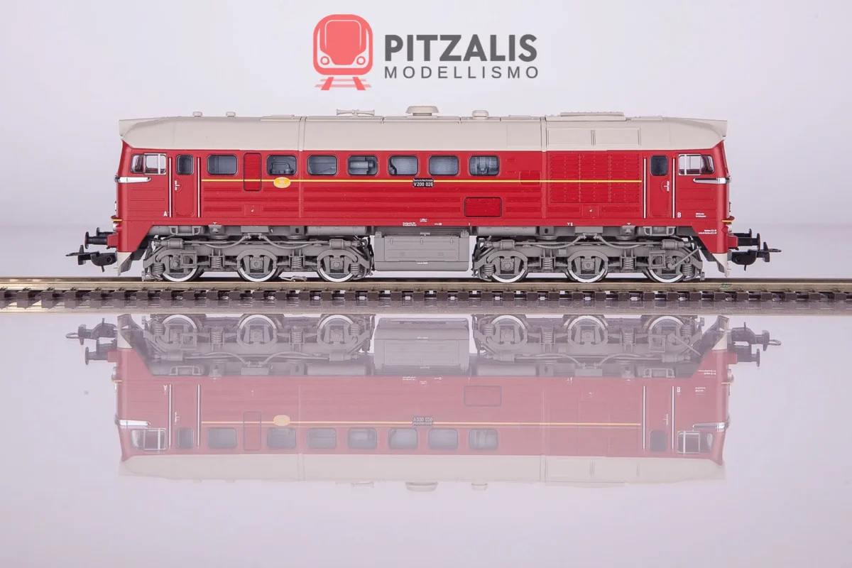 Piko 52801 Locomotiva diesel BR V200 delle DR nella colorazione rossa con striscia gialla. Vista della fiancata, con suggestivo riflesso sulla superficie traslucida.