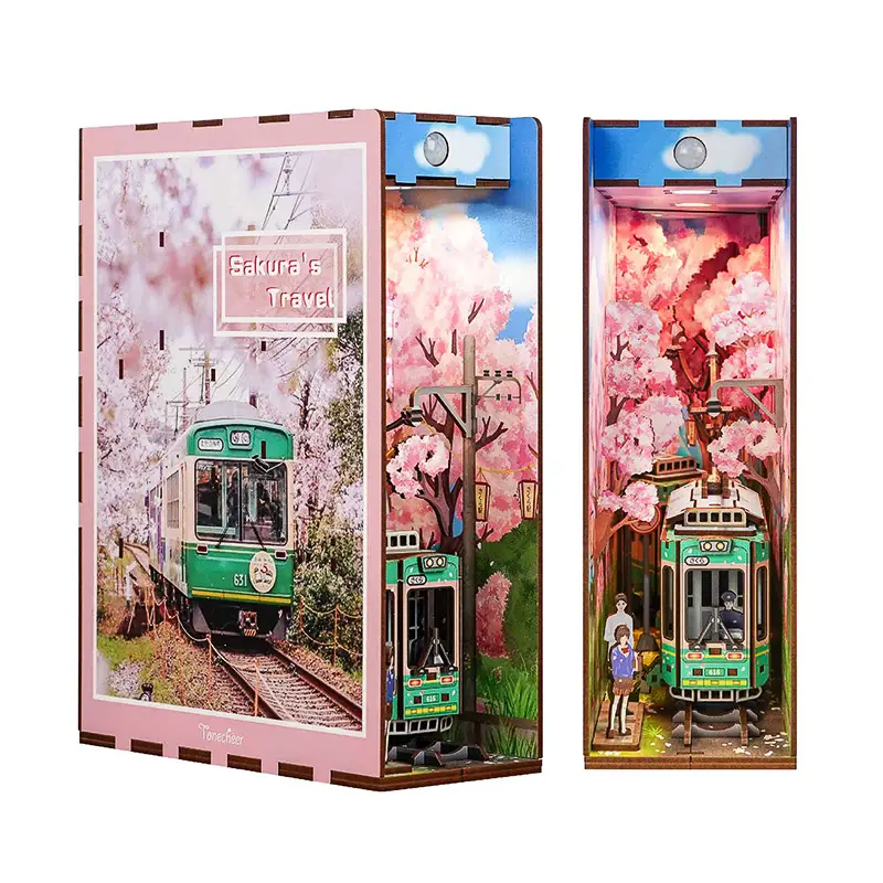 Tonecheer TQ119 Vista frontale e di tre quarti del kit book nook Sakura's Travel, puzzle 3d raffigurante un romantico tram verde in un viale tra alberi in fiore. Tutto mostrato su sfondo bianco.